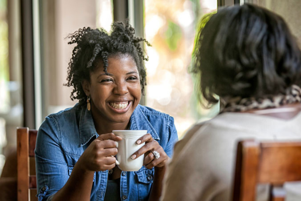 young woman having coffee with family member